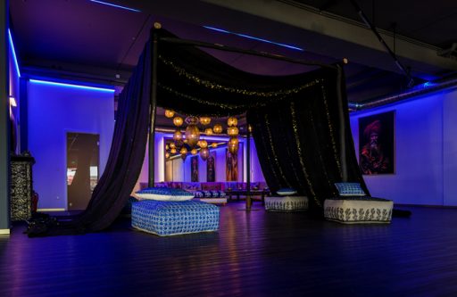 Himmelbett style mit schwarz goldenem Vorhang im offen Raum blau beläuchtet lounge style
