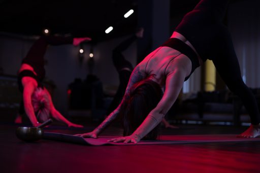 yoga übung in der gruppe ausgeführt in toller Location abgedunkelt