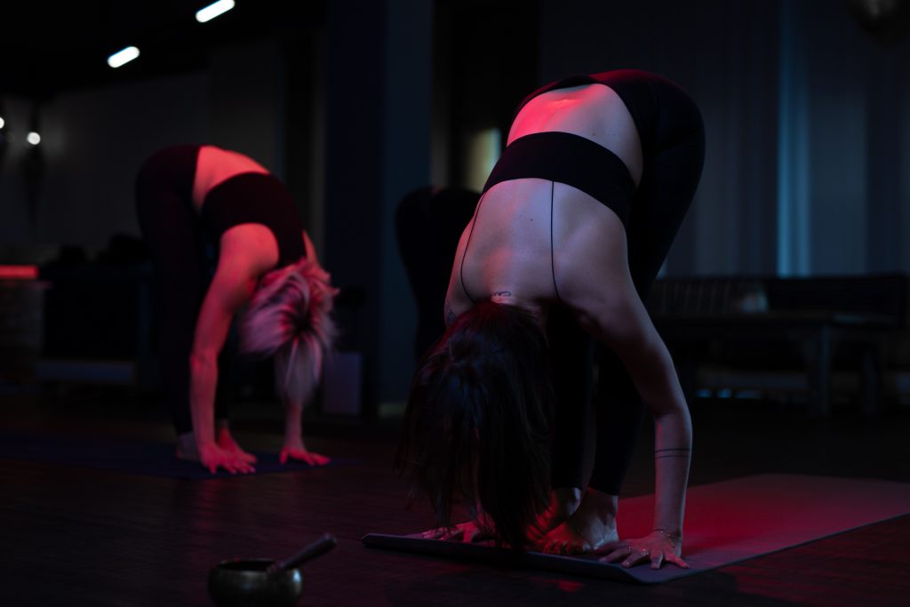 yoga übung der herabschauende Hund syncron von 2 Frauen ausgeführt