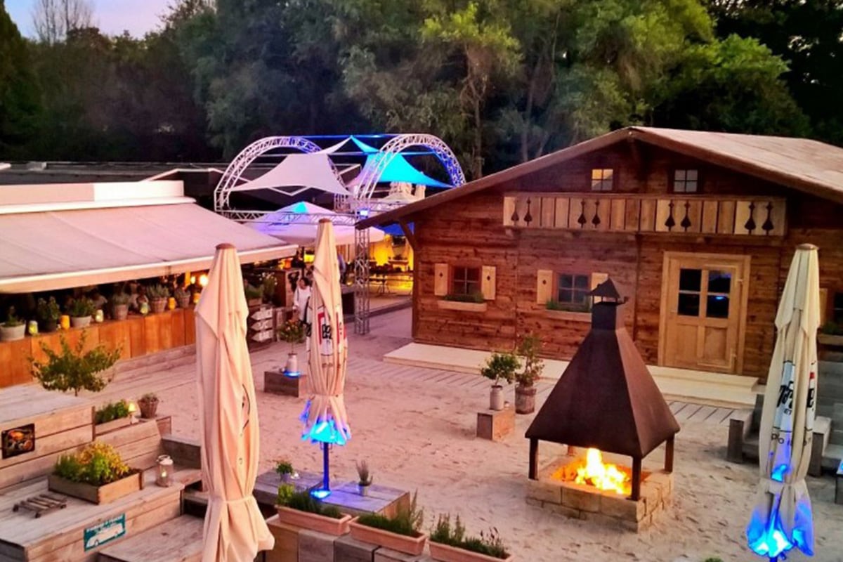 cantina-majolika-red-phat-elephant-yoga Sandstrand mit sitzbänken und holzhütte mit einem Offen in der Mitte perfekt für Events
